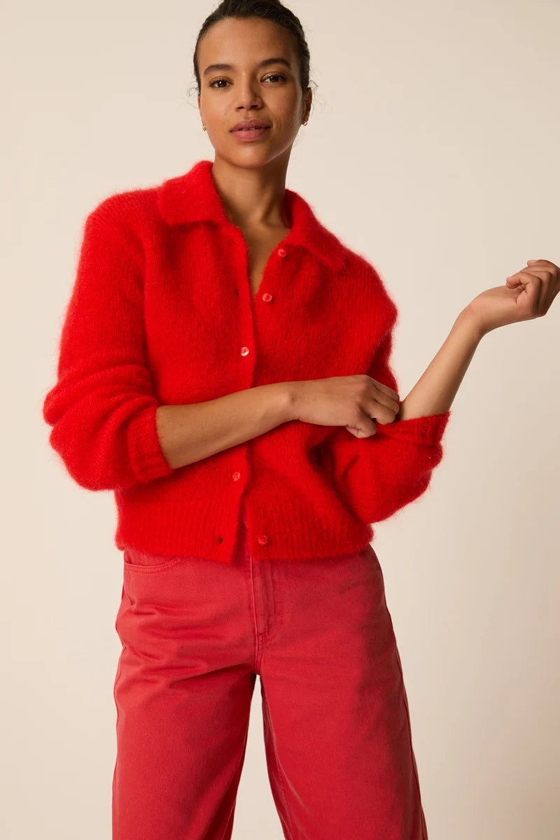 Modèle portant le gilet col polo en kid mohair rouge Alpolo DES PETITS HAUTS ajustant sa manche
