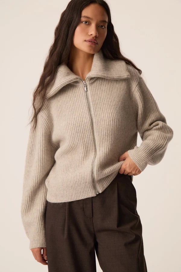 Modèle portant le gilet zippé Andrea gris galet DES PETITS HAUTS avec col ouvert et pantalon marron
