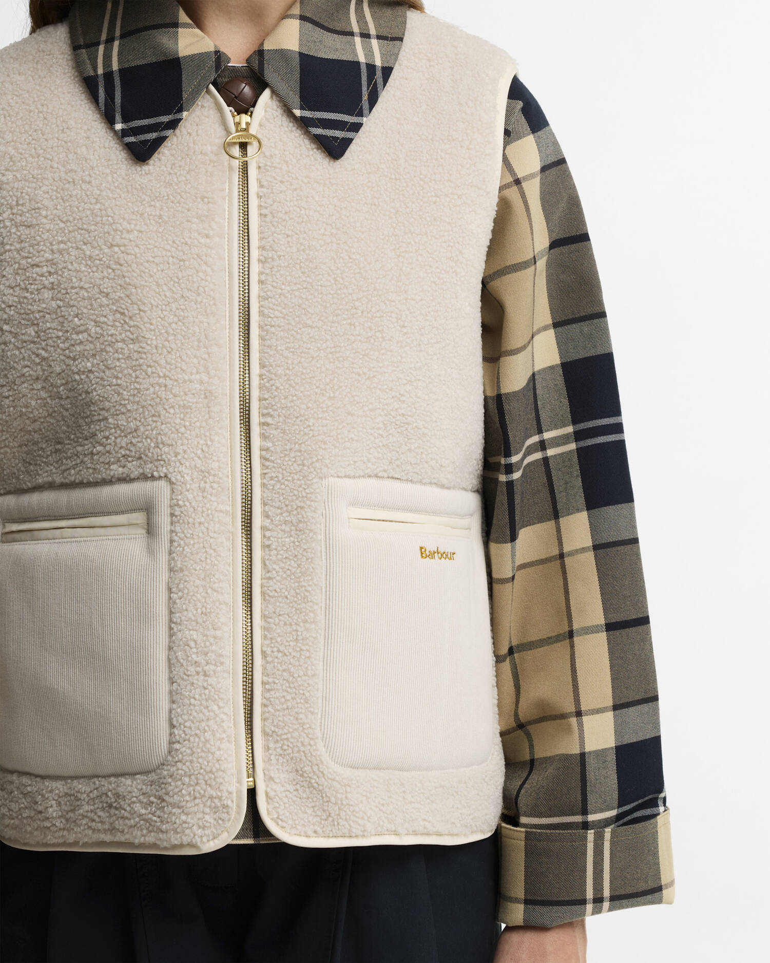 Gros plan sur la fermeture zippée en laiton, la texture moumoute et la poche en velours brodée Barbour