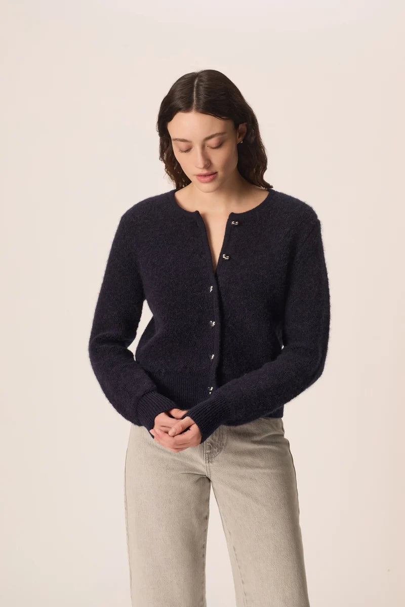 Modèle portant le gilet court bleu marine Cumin DES PETITS HAUTS avec un jean clair