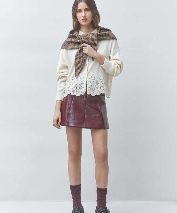 Look casual chic avec le gilet blanc cassé Gaiari SUNCOO FEMME, jupe en cuir bordeaux et pull marron sur les épaules
