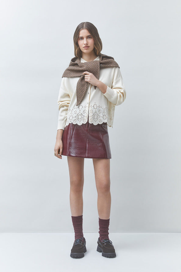 Look casual chic avec le gilet blanc cassé Gaiari SUNCOO FEMME, jupe en cuir bordeaux et pull marron sur les épaules