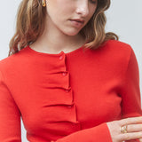 Gros plan sur les plis drapés et les boutons ton sur ton du gilet rouge SUNCOO FEMME Gamira