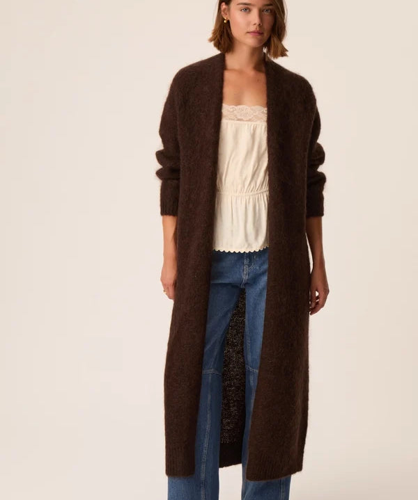 Modèle portant le gilet long marron foncé Aurore DES PETITS HAUTS avec jean brut et top écru