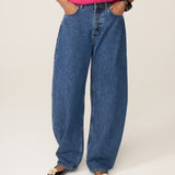 Visuel porté des jambes et des pieds du jean délavé bleu moyen FABIENNE CHAPOT Betty Barrel avec un pull rose