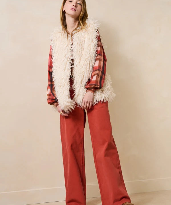 Vue d'ensemble du look avec le jean ample Gustol terracotta, gilet sans manche en fausse fourrure et chemise