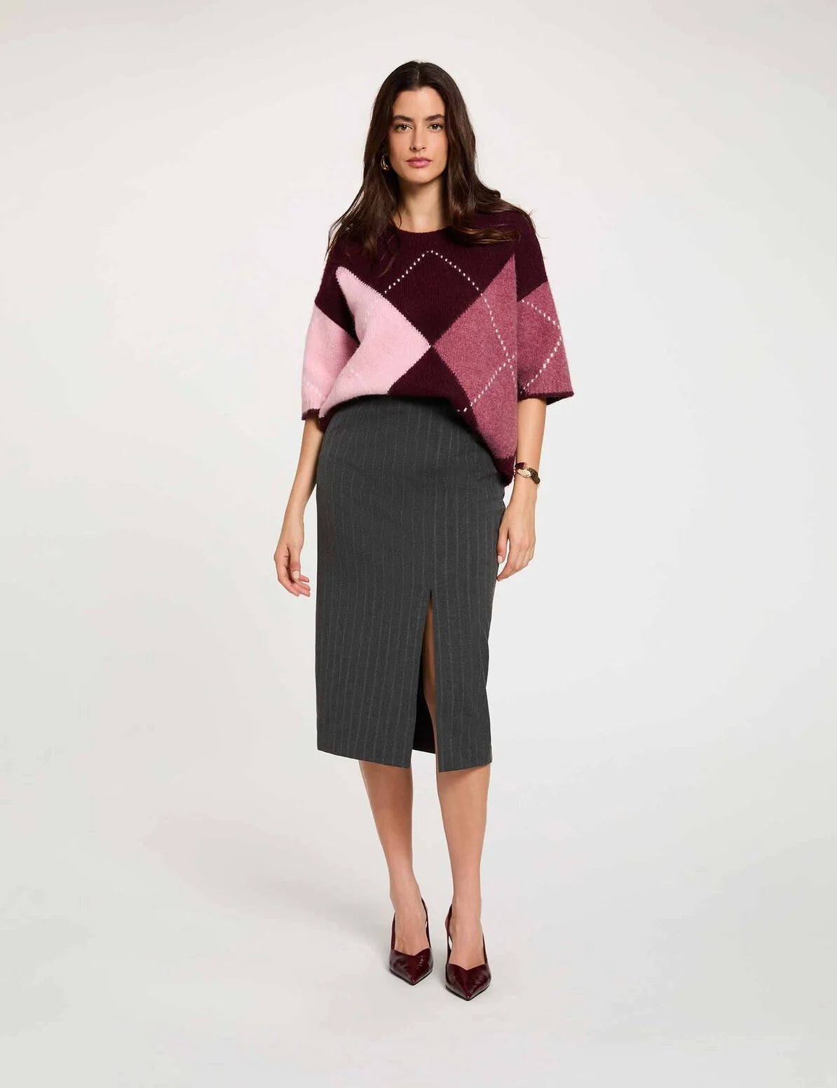 Vue de face d'un modèle portant la jupe crayon taille haute gris foncé MORGAN Jcosy fendue longueur 3/4 portée avec un pull ample en maille et des des escarpins