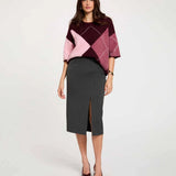 Vue de face d'un modèle portant la jupe crayon taille haute gris foncé MORGAN Jcosy fendue longueur 3/4 portée avec un pull ample en maille et des des escarpins