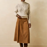 Silhouette complète portée avec la jupe velours cognac Genaro LA FÉE MARABOUTÉE, pull col montant écru et bottes suédées