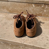Vue arrière des mocassins camel en daim LORA posés sur des marches