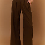 Pantalon large gris carbone SUNCOO Jovial porté de face avec une ceinture fine noire et un pull en maille rayé