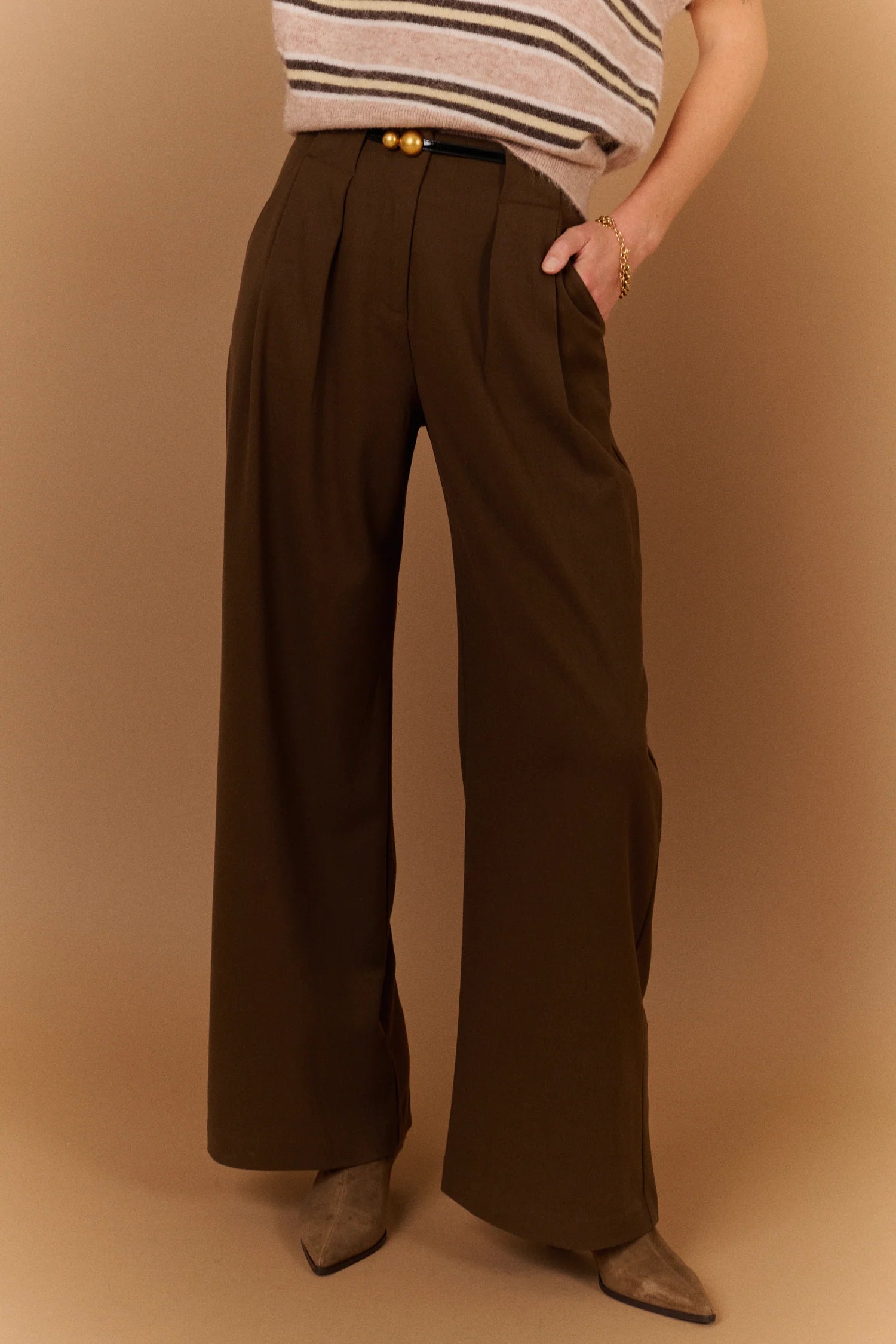 Pantalon large gris carbone SUNCOO Jovial porté de face avec une ceinture fine noire et un pull en maille rayé