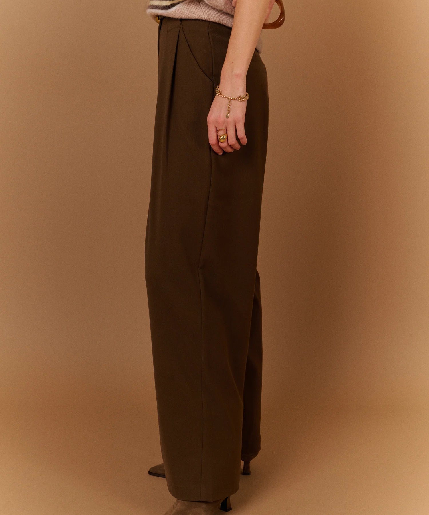 Vue de profil du pantalon large gris carbone SUNCOO Jovial avec une ceinture fine noire et un pull en maille rayé