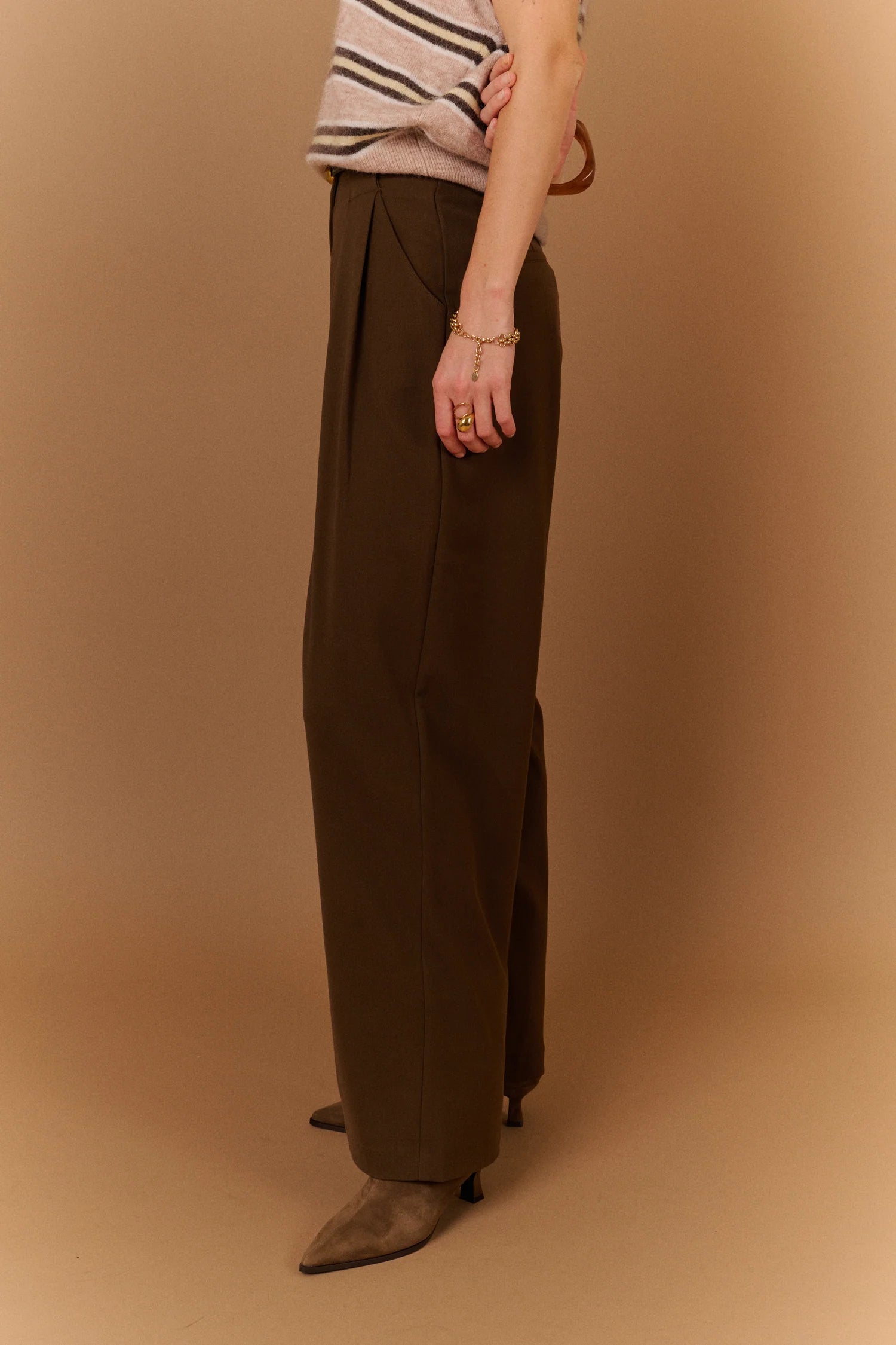 Vue de profil du pantalon large gris carbone SUNCOO Jovial avec une ceinture fine noire et un pull en maille rayé