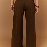 Pantalon large gris carbone SUNCOO Jovial porté de dos avec une ceinture fine noire et un pull en maille rayé