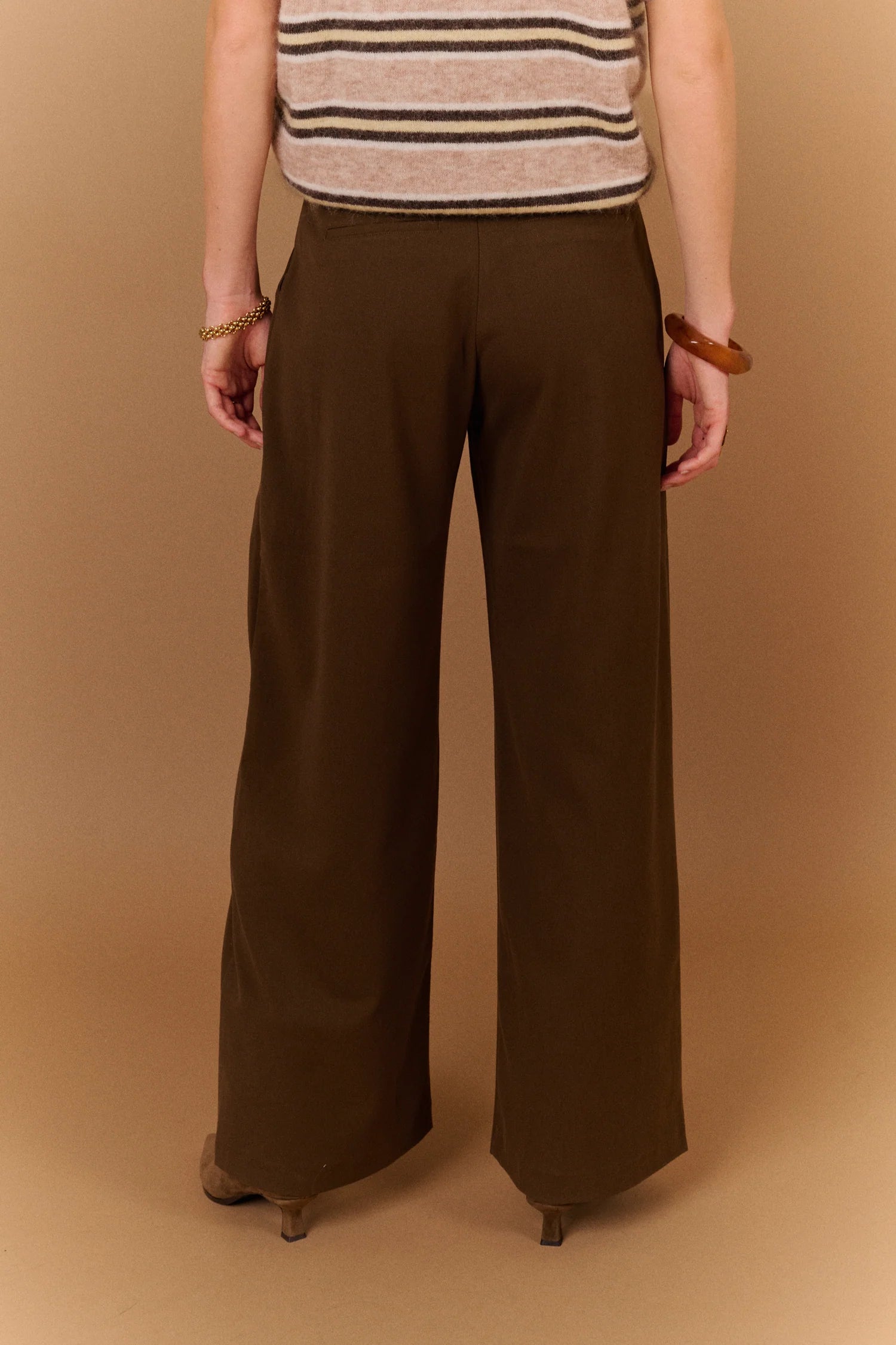 Pantalon large gris carbone SUNCOO Jovial porté de dos avec une ceinture fine noire et un pull en maille rayé
