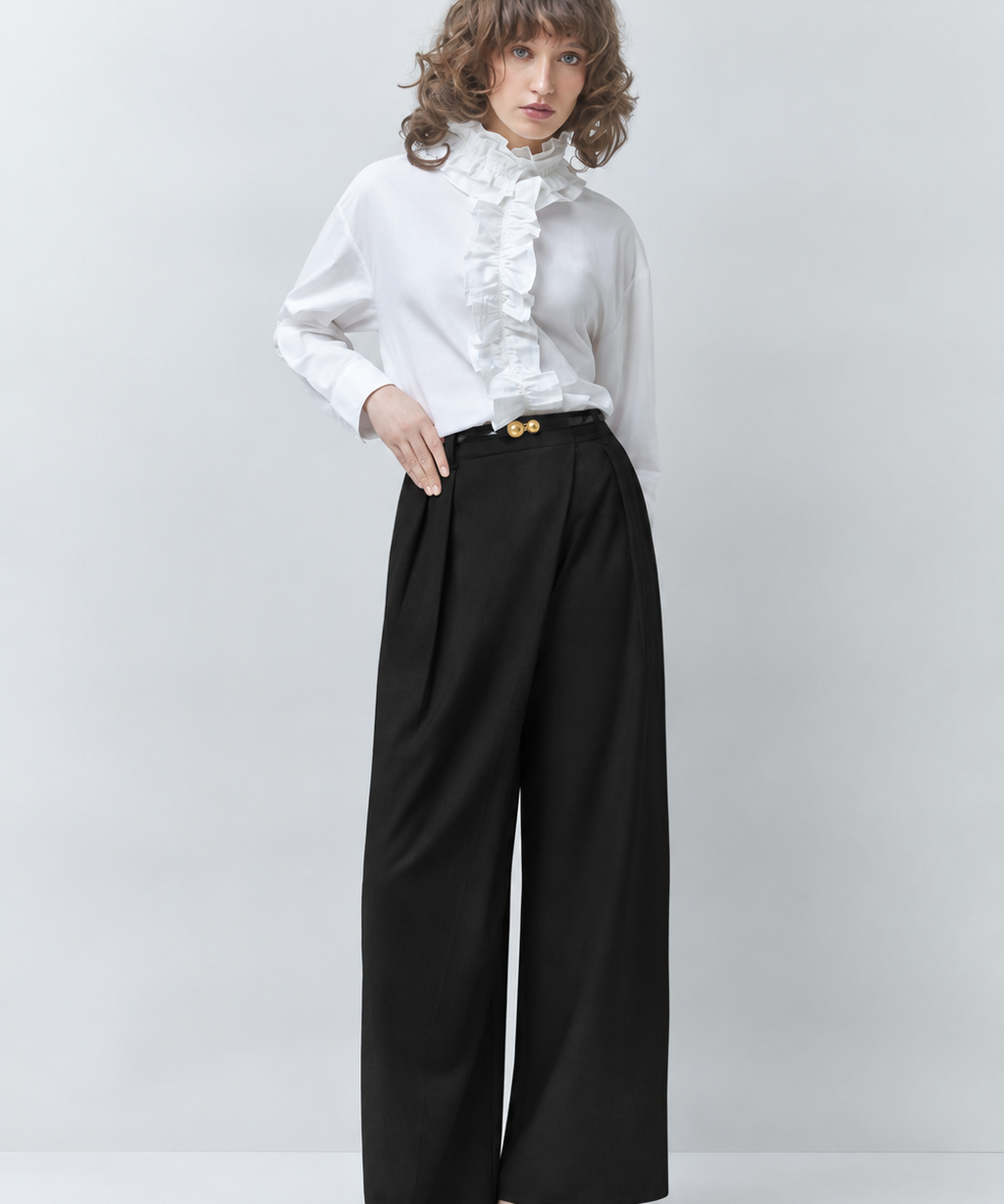 Silhouette complète du pantalon large noir SUNCOO FEMME Jupiter porté par un mannequin avec une chemise blanche à volants