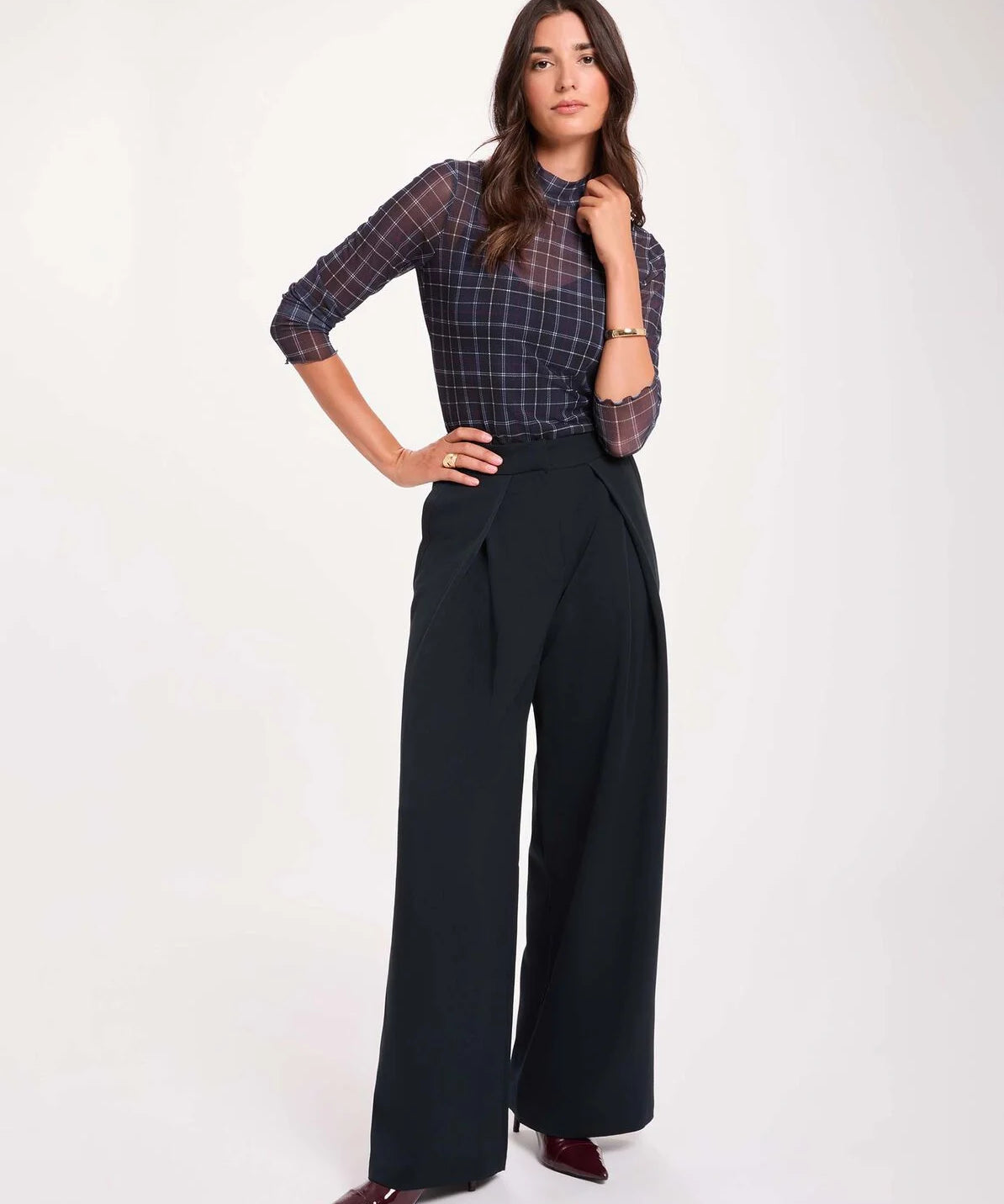 Pantalon large bleu marine MORGAN Pwrap à plis croisés porté de face avec un top ajusté à carreaux en transparence et des escarpins