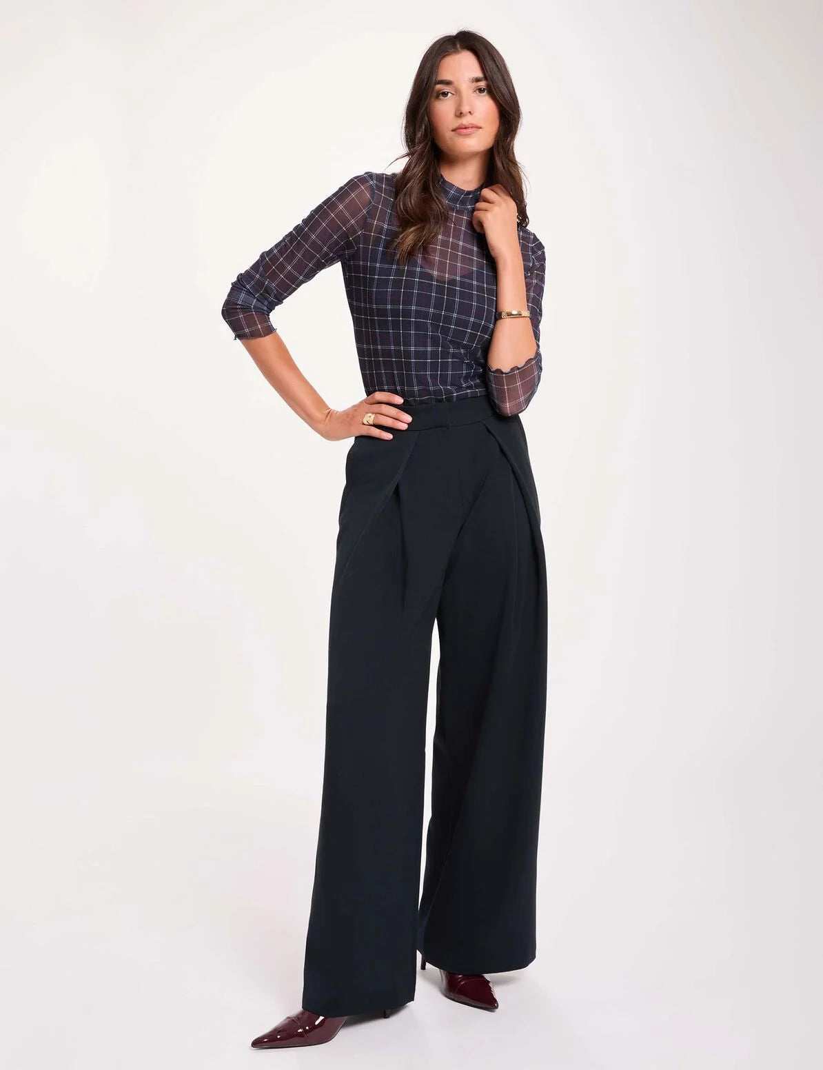 Pantalon large bleu marine MORGAN Pwrap à plis croisés porté de face avec un top ajusté à carreaux en transparence et des escarpins