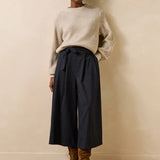 Vue d'ensemble du look avec la jupe-culotte Dactus anthracite, un pull écru en maille et des bottines en daim marron