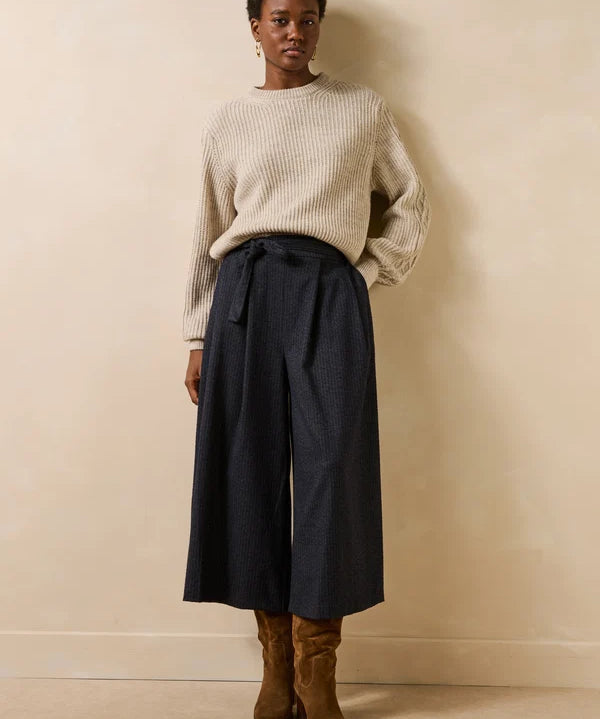 Vue d'ensemble du look avec la jupe-culotte Dactus anthracite, un pull écru en maille et des bottines en daim marron