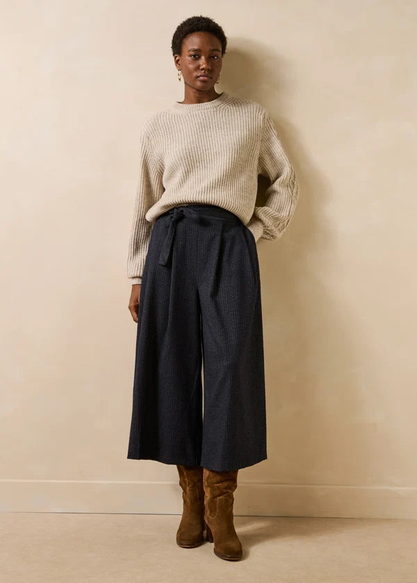 Vue d'ensemble du look avec la jupe-culotte Dactus anthracite, un pull écru en maille et des bottines en daim marron