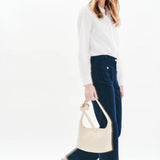 Silhouette complète avec le pantalon velours marine CAROLL Pelley, chemise blanche et sac crème