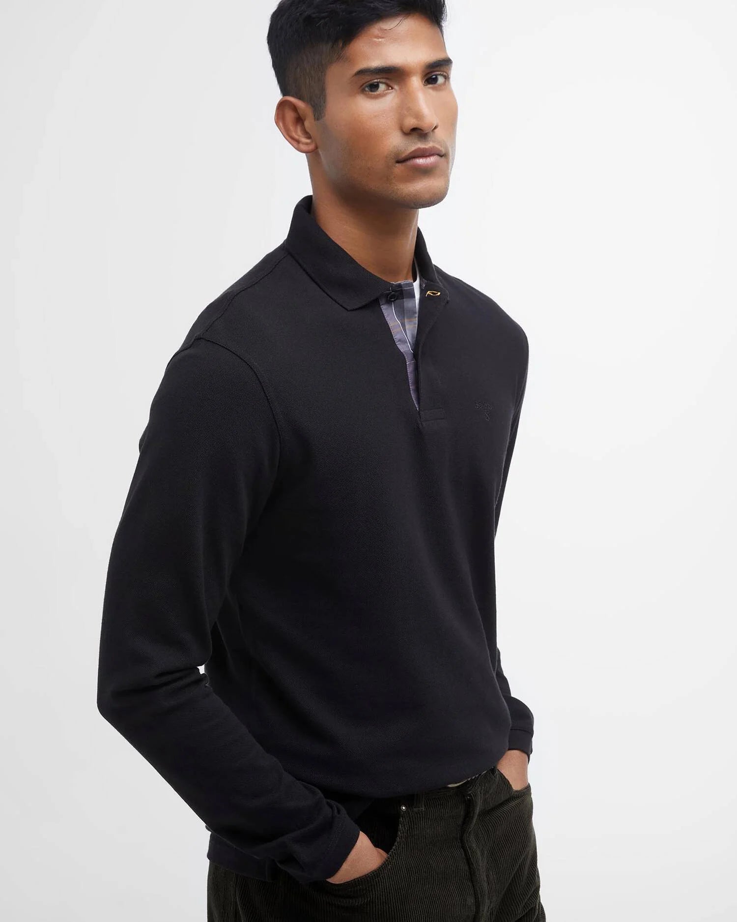 Portrait de trois-quarts du mannequin arborant le polo noir Barbour homme