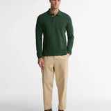 Plan entier du mannequin vêtu du polo vert foncé Barbour, chino beige et bottines