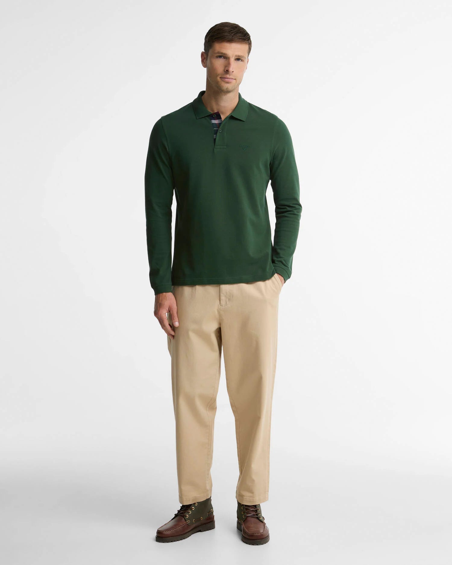 Plan entier du mannequin vêtu du polo vert foncé Barbour, chino beige et bottines