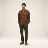 Silhouette complète portée avec le polo rugby marron brownie SERGE BLANCO, pantalon vert et chaussures marron