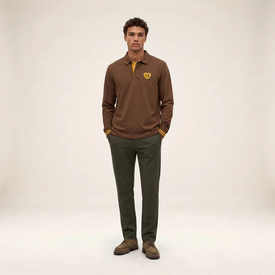 Silhouette complète portée avec le polo rugby marron brownie SERGE BLANCO, pantalon vert et chaussures marron