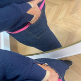 Gros plan sur la fente des poignets avec liseré beige et le bord-côte rose du pull PU620
