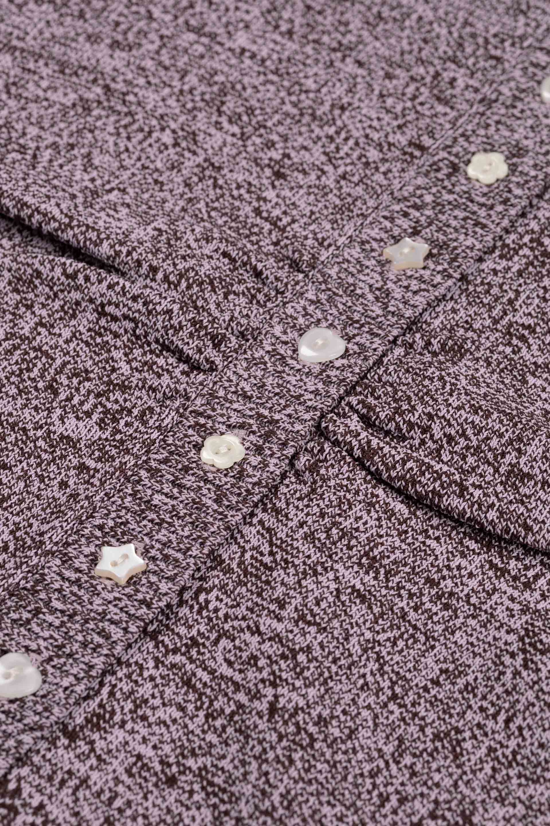 Gros plan sur la maille chinée et les boutons fantaisie en forme d'étoile et de cœur du pull Tilda
