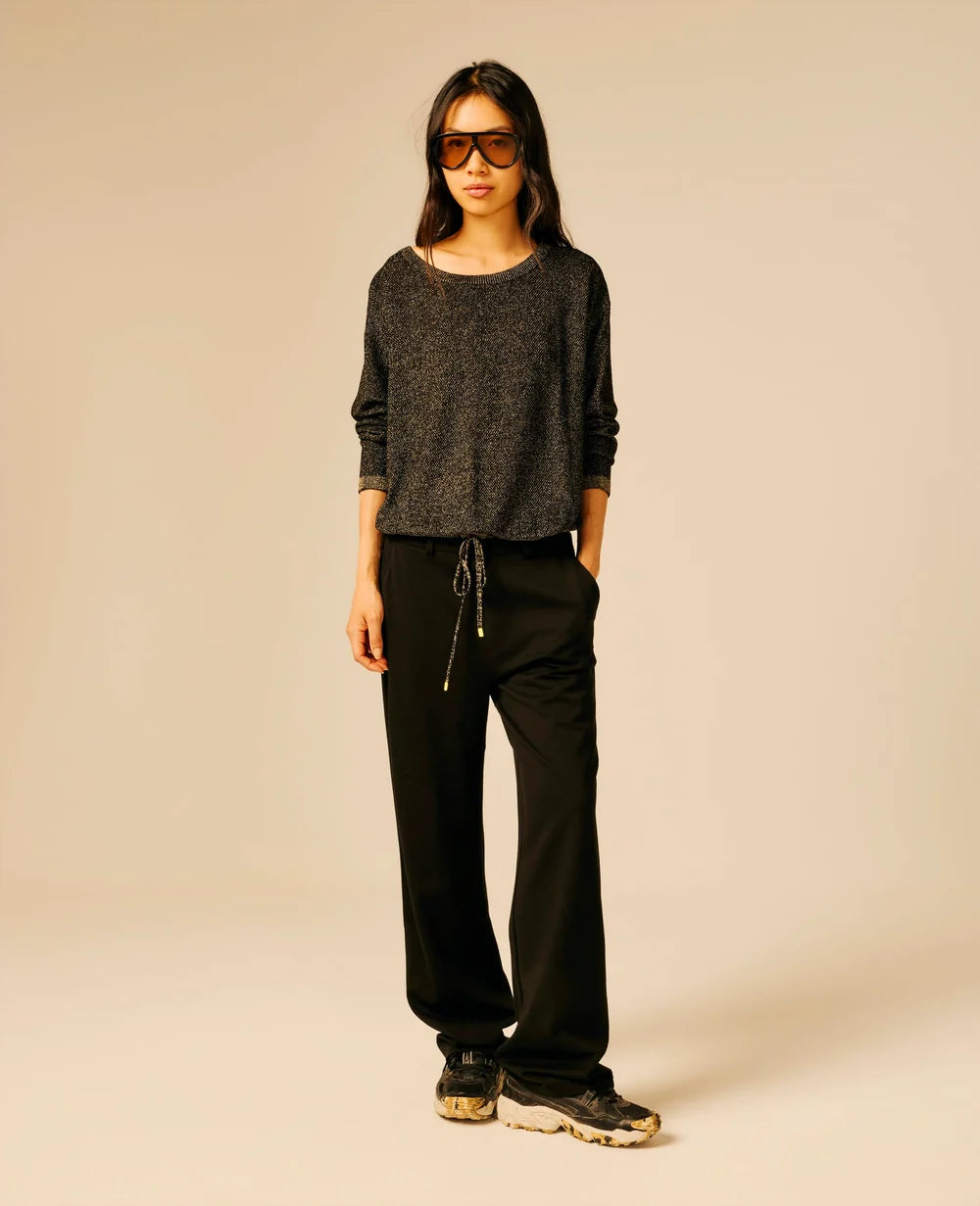 Pull noir et doré pailleté SUN VALLEY FEMME Ubden porté de face avec un pantalon noir fluide