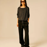 Pull noir et doré pailleté SUN VALLEY FEMME Ubden porté de face avec un pantalon noir fluide
