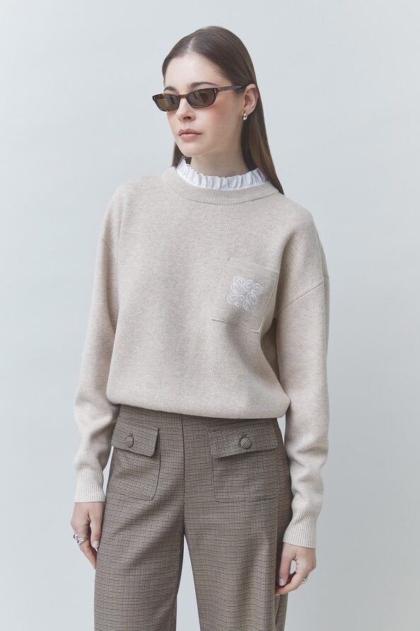 Zoom sur le col volanté blanc amovible et la poche brodée du pull beige SUNCOO FEMME Pacoli