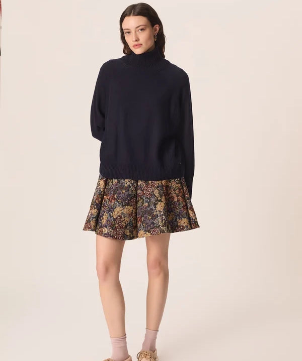 Vue d ensemble du pull col roulé marine Aramis DES PETITS HAUTS porté avec une jupe courte imprimée