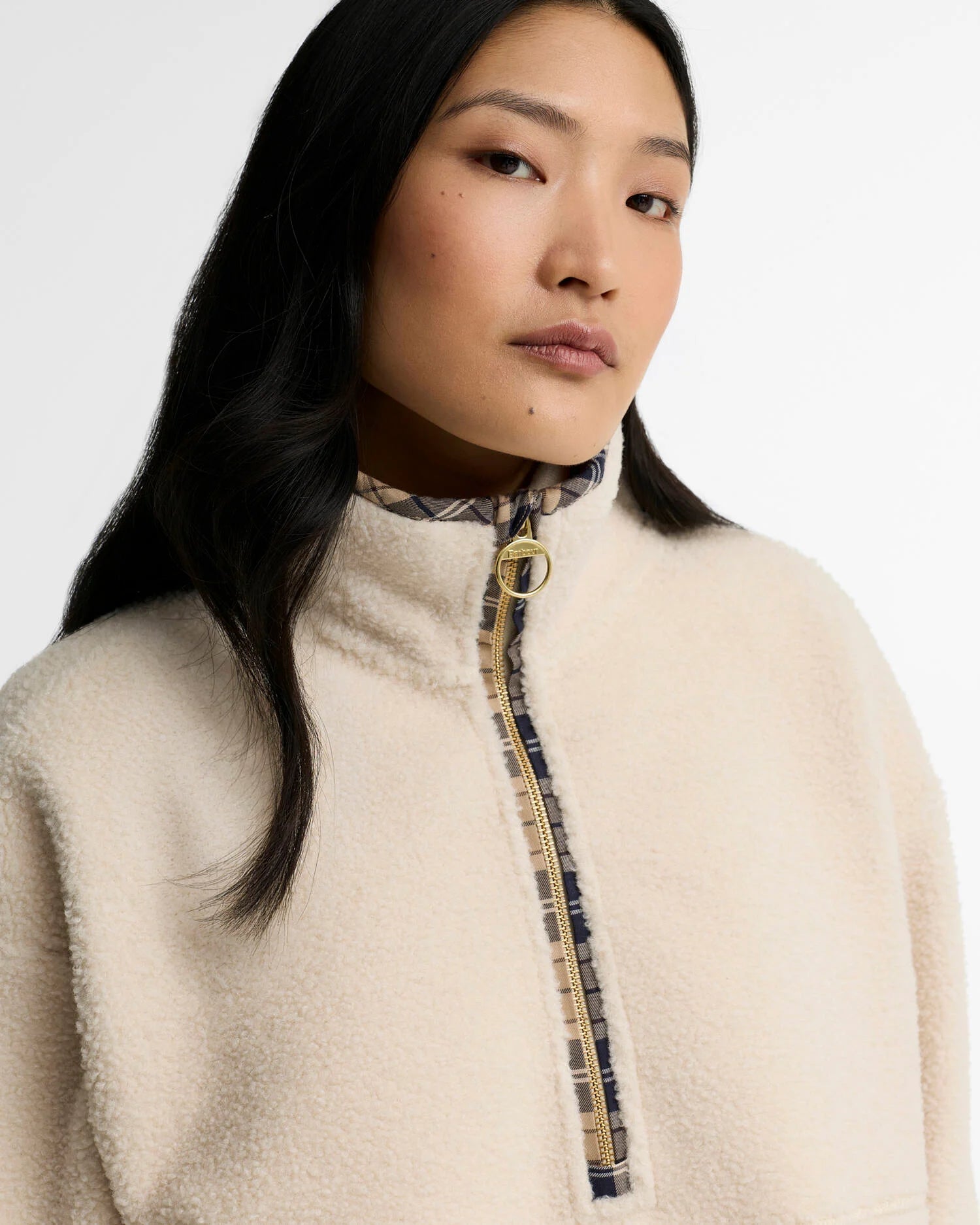 Gros plan sur le demi-zip du pull polaire Merys Barbour, la tirette anneau dorée et la bordure tartan
