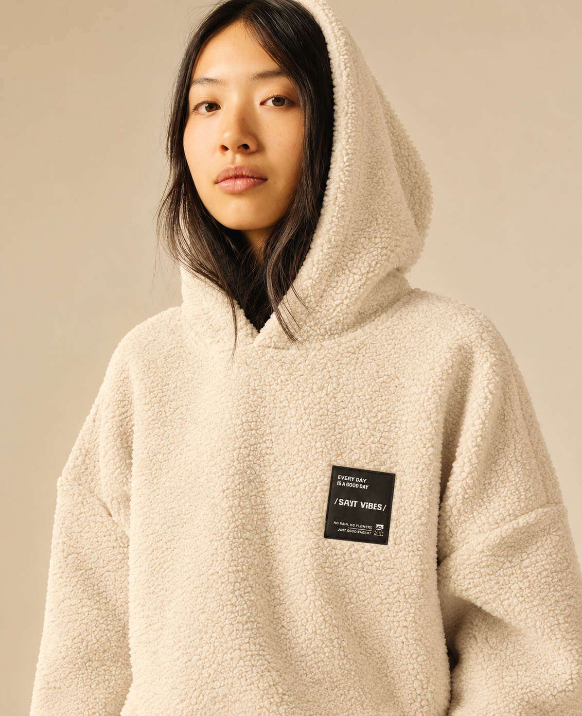 Zoom sur la capuche en maille sherpa beige et le patch noir poitrine du sweat SUN VALLEY FEMME Deltry
