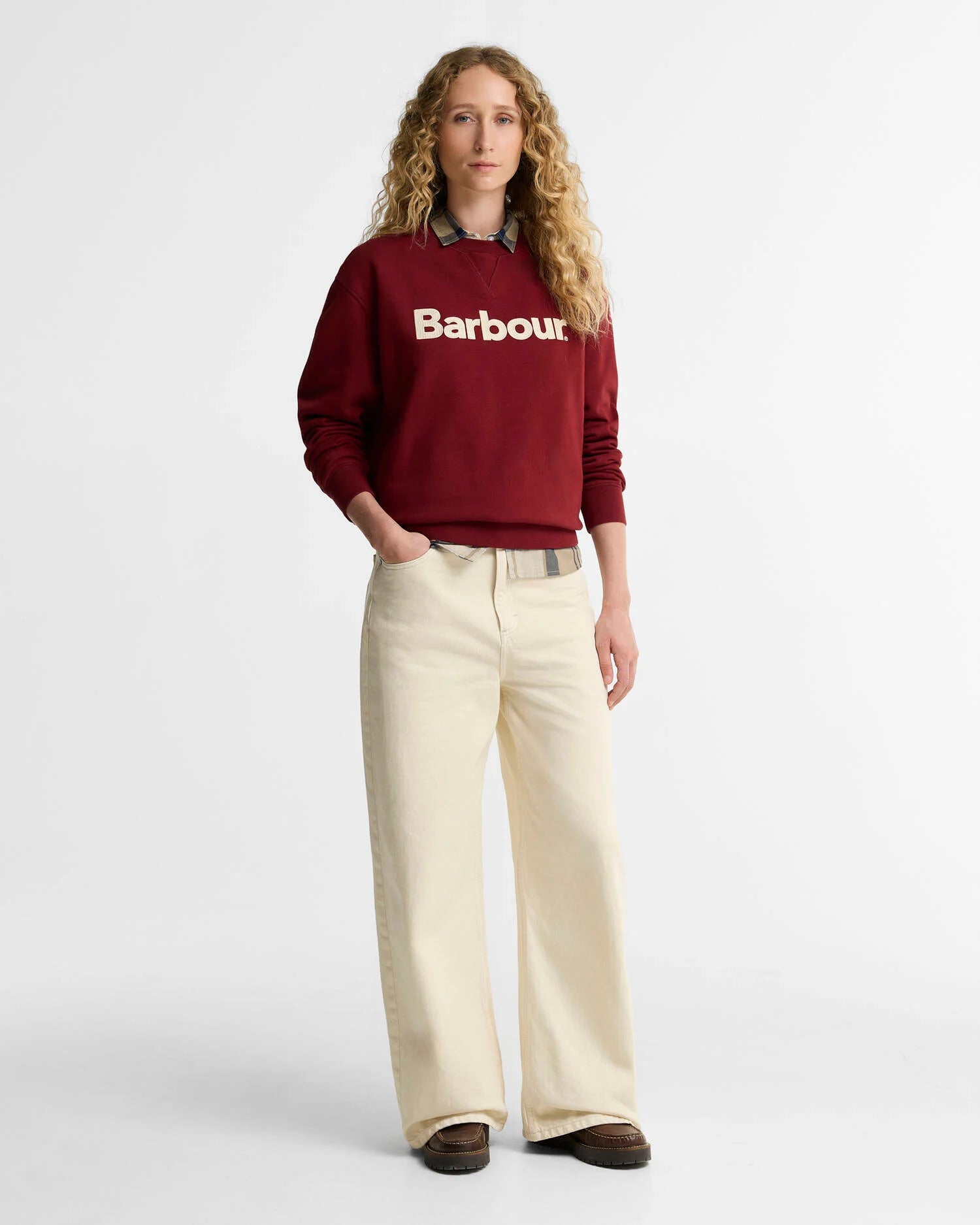 Vue d'ensemble du look avec le sweat rouge canneberge Barbour, un jean beige large et des chaussures en cuir