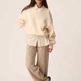 Vue de face du sweat oversize crème Jonas DES PETITS HAUTS avec un pantalon large et une chemise rayée 