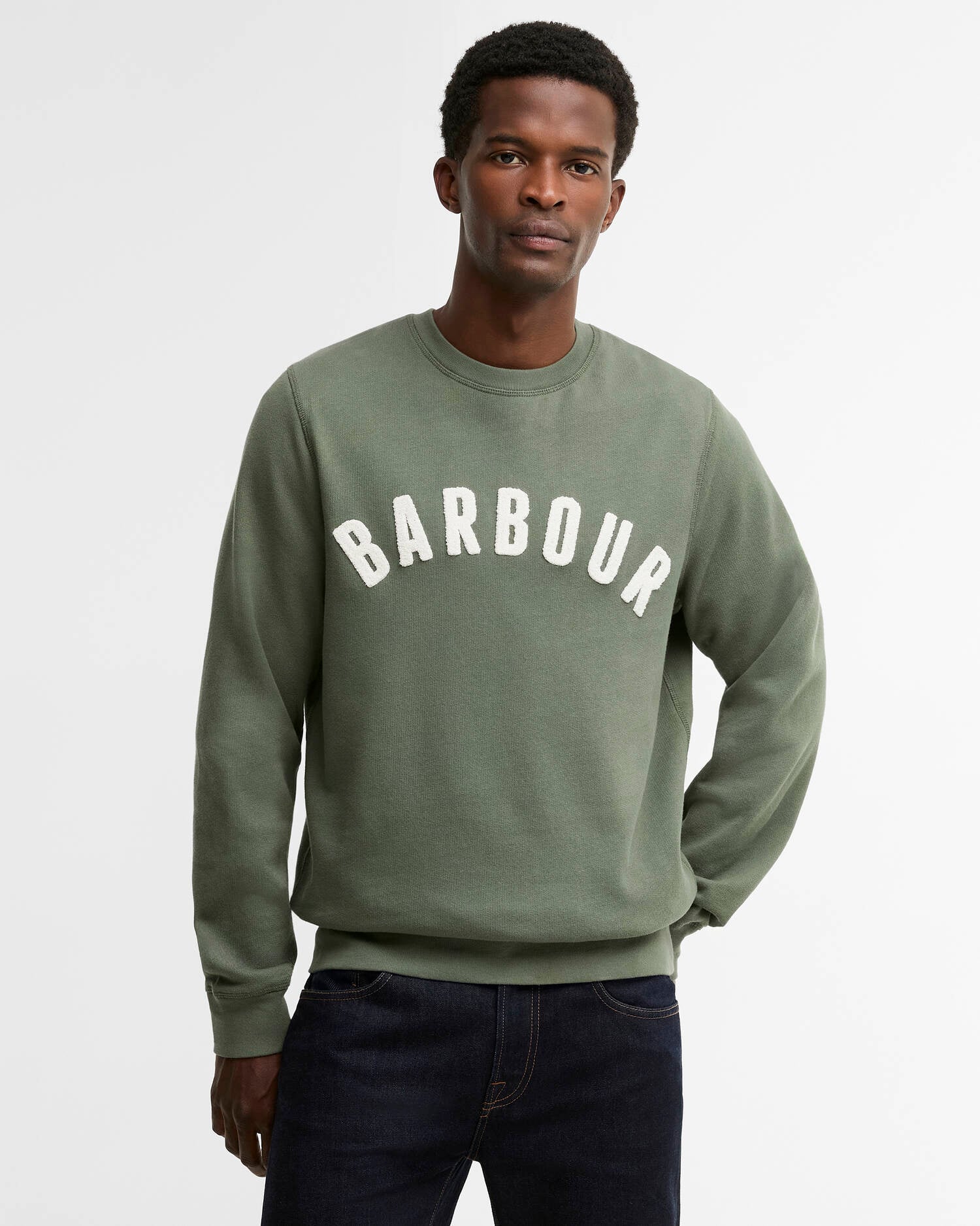 Mannequin portant le sweat Prep vert thym BARBOUR HOMME avec un jean brut