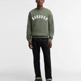 Look complet avec le sweat-shirt vert thym Barbour, jean foncé et chaussures bateau marron