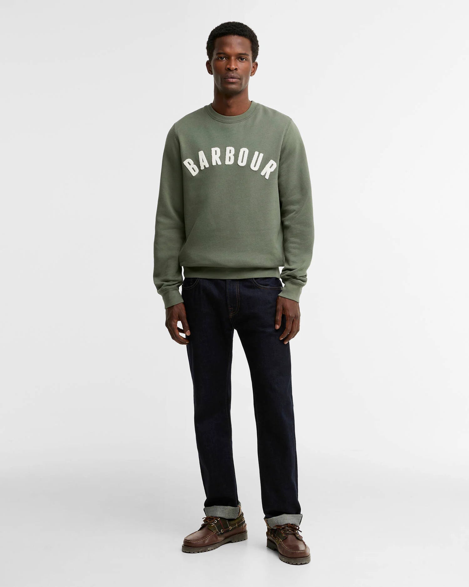 Look complet avec le sweat-shirt vert thym Barbour, jean foncé et chaussures bateau marron
