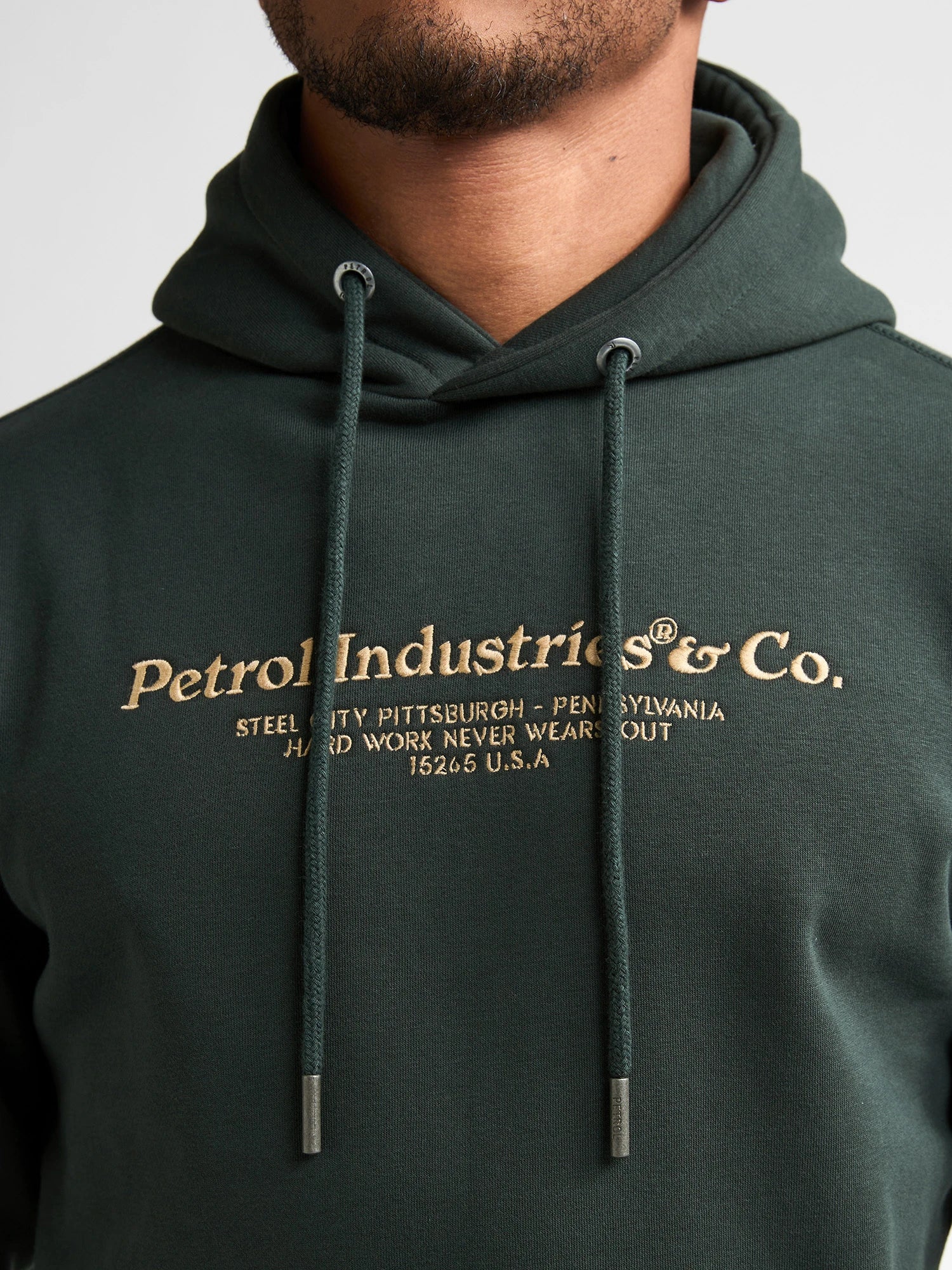 Zoom sur l'imprimé logo poitrine et le cordon de la capuche du sweat vert Petrol Industries