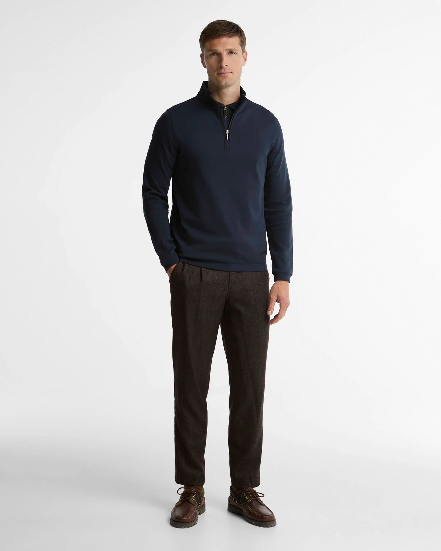 Look complet avec le sweat demi-zip marine Barbour, pantalon foncé et chaussures en cuir marron