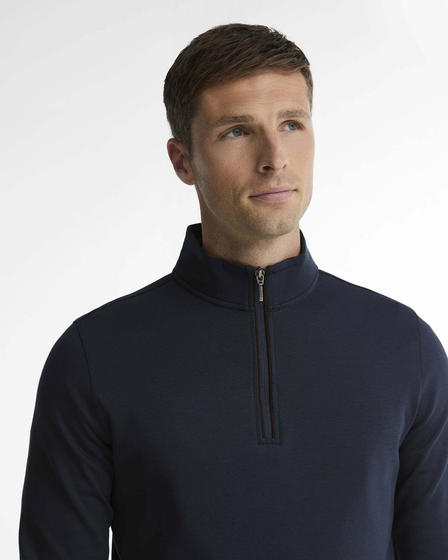 Gros plan du col montant zippé et de la finition Alcantara sur le sweat marine Barbour