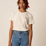 Modèle portant le t-shirt écru Ilian DES PETITS HAUTS avec écusson cœur brodé et jean bleu
