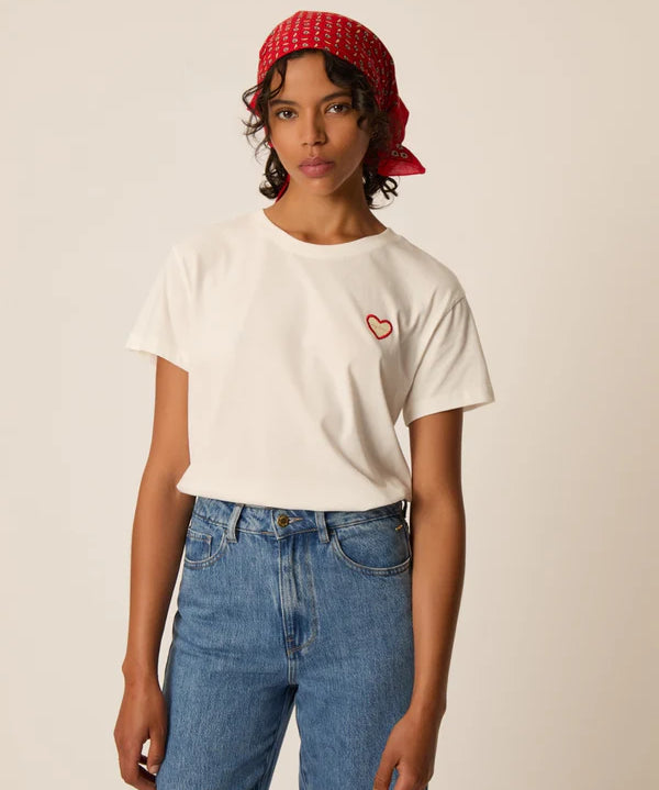 Modèle portant le t-shirt écru Ilian DES PETITS HAUTS avec écusson cœur brodé et jean bleu